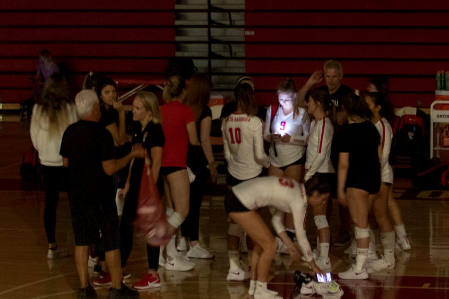 Vaquero volleyball players huddle around and wait for information about the power outage on Friday, Sept. 20, 2019, in theSports Pavilion at City College in Santa Barbara, Calif. The game was eventually canceled.