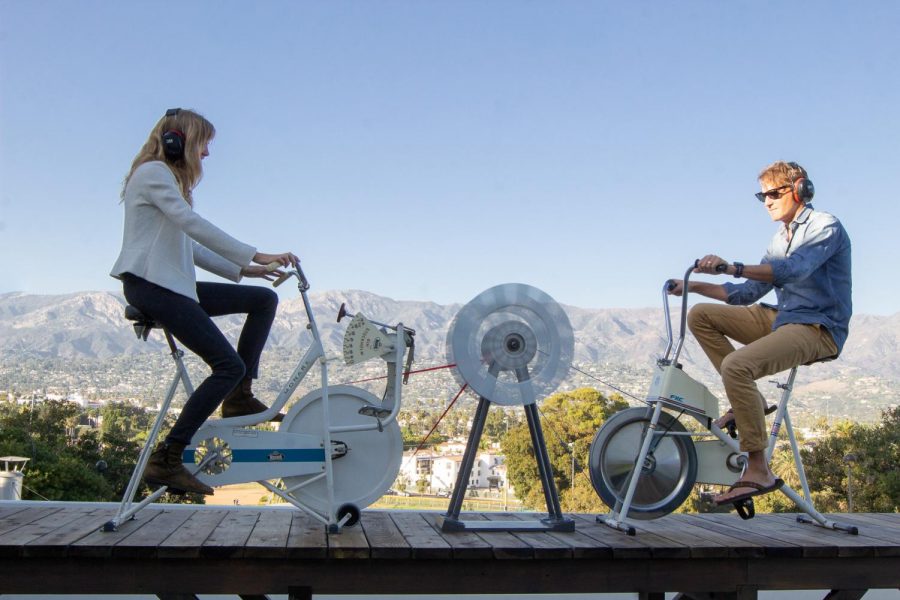 Gallery attendees try out the interactive bike sculpture created by Artist and UCSB professor Jane Mulfinger featured in the solo exhibition West is South on Friday, Oct. 4, 2019, at the Atkinson Gallery at City College in Santa Barbara, Calif. The bikes ring bells when peddled and were built in the UCSB woodshop lab by Mulfinger using exercise bikes from the 1960’s.