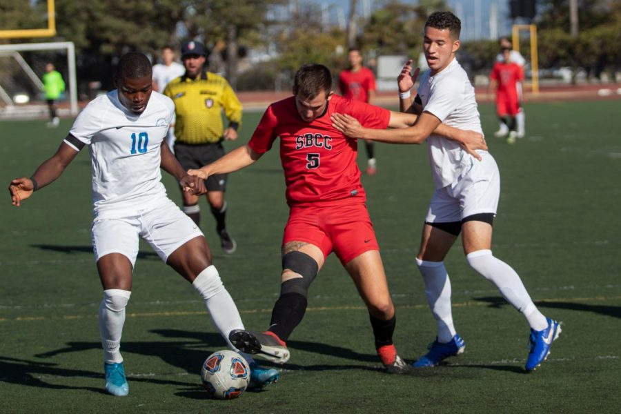 Roni Spektor (No.5) trying to force his way through two Santa Monica College defenders on Sunday, Nov. 10, 2019, at La Playa Stadium at City College in Santa Barbara, Calif.