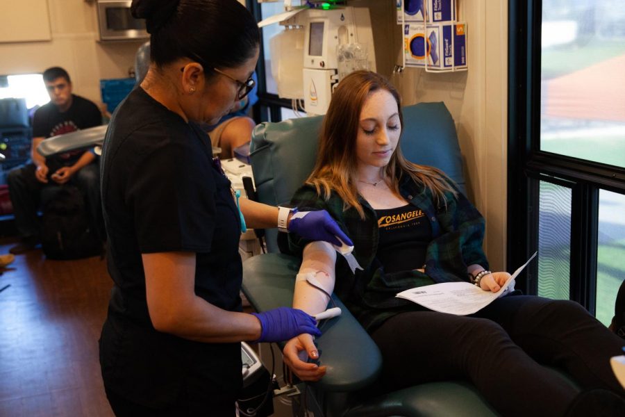 Kaitlyn Wyman has the needle removed from her arm after giving blood for the first time at the blood drive on West Campus in front of the Luria library hosted by Vitalent, the Student Nurses Association and Men in Nursing on Monday, Nov. 25, 2019, in Santa Barbara, Calif. “I’m just trying not to faint,” said Wyman “I’m just reading these tips on how to not faint to distract myself.”