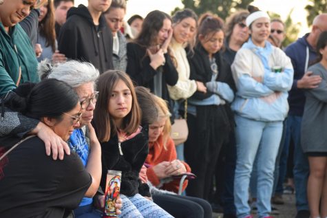 Ashley Luna, left, comforts the family members of Mary-Jane and Adolfo Corral during a memorial service held Monday on Cathedral Oaks Road near Winchester Canyon in Goleta, Calif.