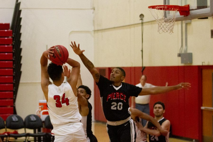 Forward Carlos Arevalo (No. 34) sinks a shot over the outstretched arm of LA Pierce’s Jayson Moore (No. 20) on Feb. 19, 2020 in the Sports Pavilion at City College in Santa Barbara, Calif. The Vaqueros lost the game 60-51.