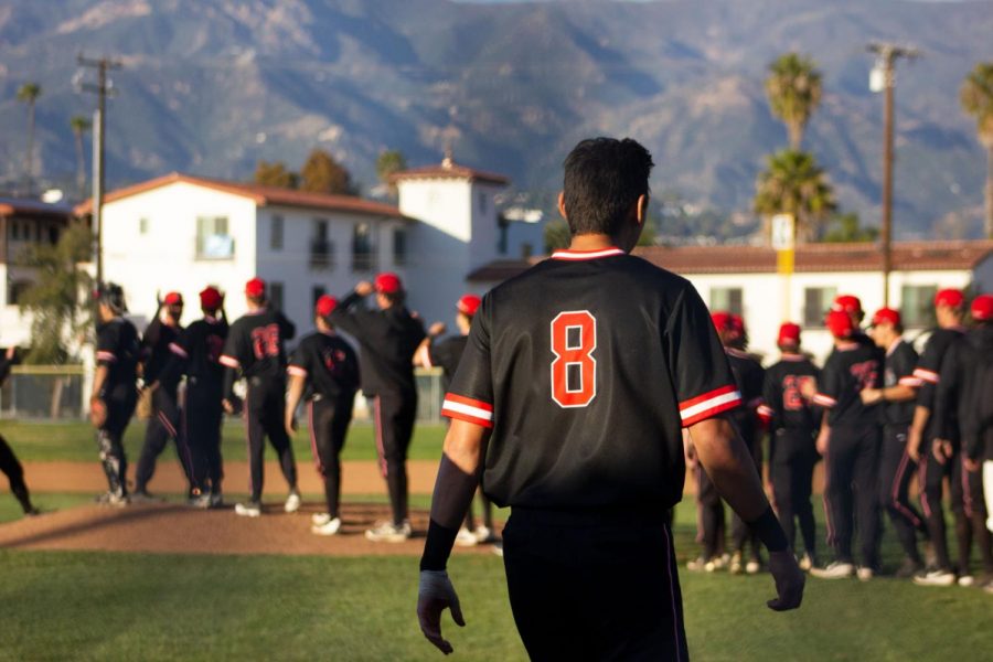 Kyle Froemke takes the field to congratulate his teammates after the Vaqueros beat Oxnard City College 10-1 on Thursday, Feb. 20 at Pershing Park in Santa Barbara, Calif. The baseball teams season has now been suspended after a vote by the CCCAA, along with all other spring sports.