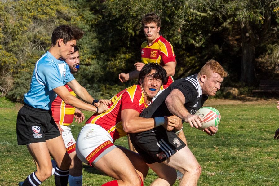 Patrick Moulder (No.7) pushes through multiple Trojans during the Santa Barbara Rugby Academy match against the University of South California on Saturday, Feb. 1, 2020, at Elings Park in Santa Barbara, Calif. The Academy beat the Trojans 78-7.