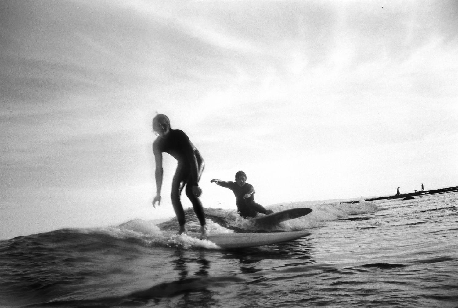 Luke Williams (right) and younger brother Jake Williams share a wave at Leadbetter Beach on Wednesday, Feb. 26 in Santa Barbara, Calif. Luke and Jake grew up in Ventura, Calif., and have been surfing since they were young teenagers.