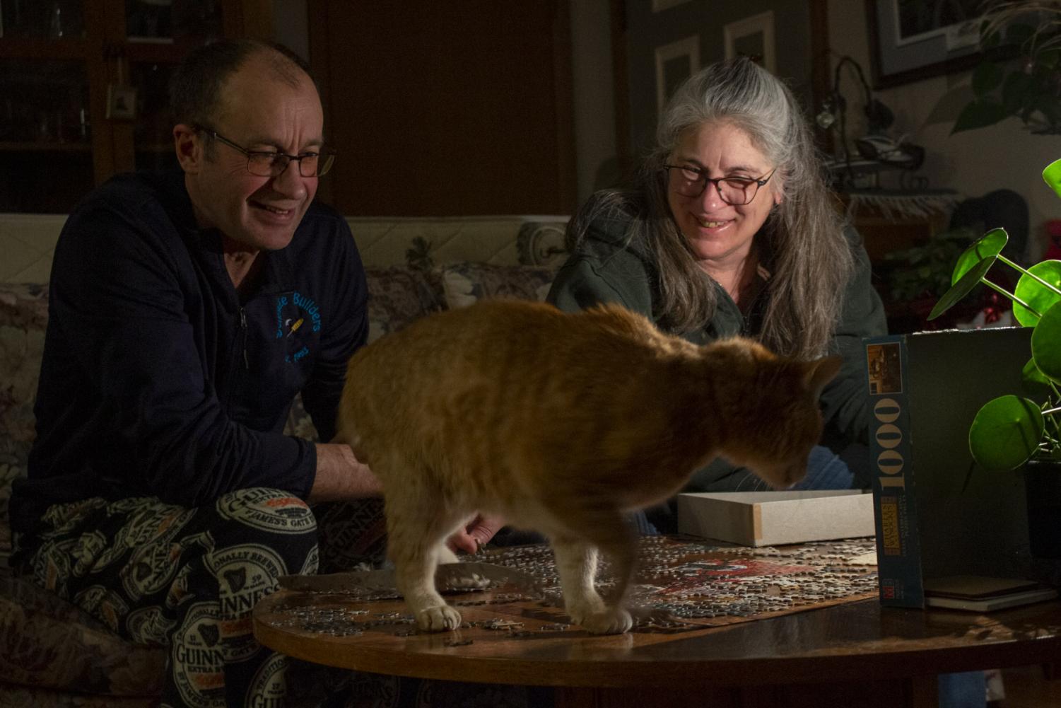 Mitch Scrage and Terese Brunner share a laugh over their cat Sully jumping on the table and on top of the puzzle they started together on April 6, 2020 at their home in New Holstein, Wis. Throughout the uncertainty of shelter in place orders Brunner and Schrage have been enjoying the extra time together.