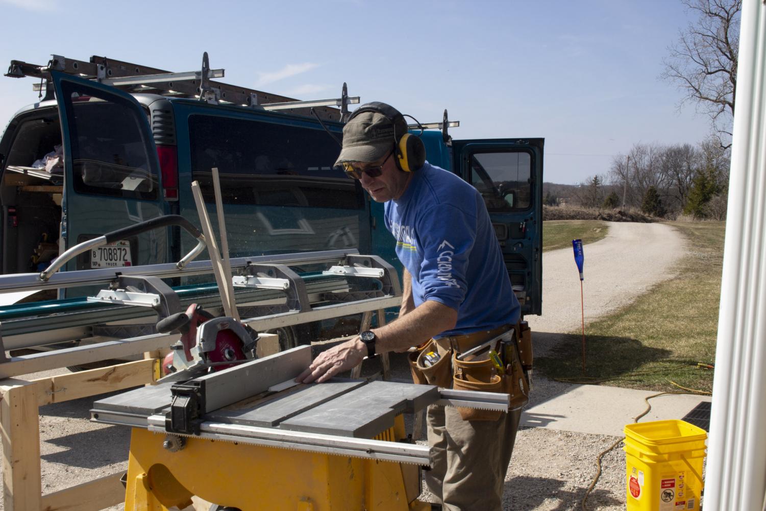 Mitch Schrage trims a part needed for the new screens he is installing on his house on April 2, 2020, at his home in New Holstein, Wis. Schrage is an independent contractor and does not get the same luxury of time off as people will always need a door fixed, porches redone, windows put in, and sometimes the occasional toilet paper holder screwed in.