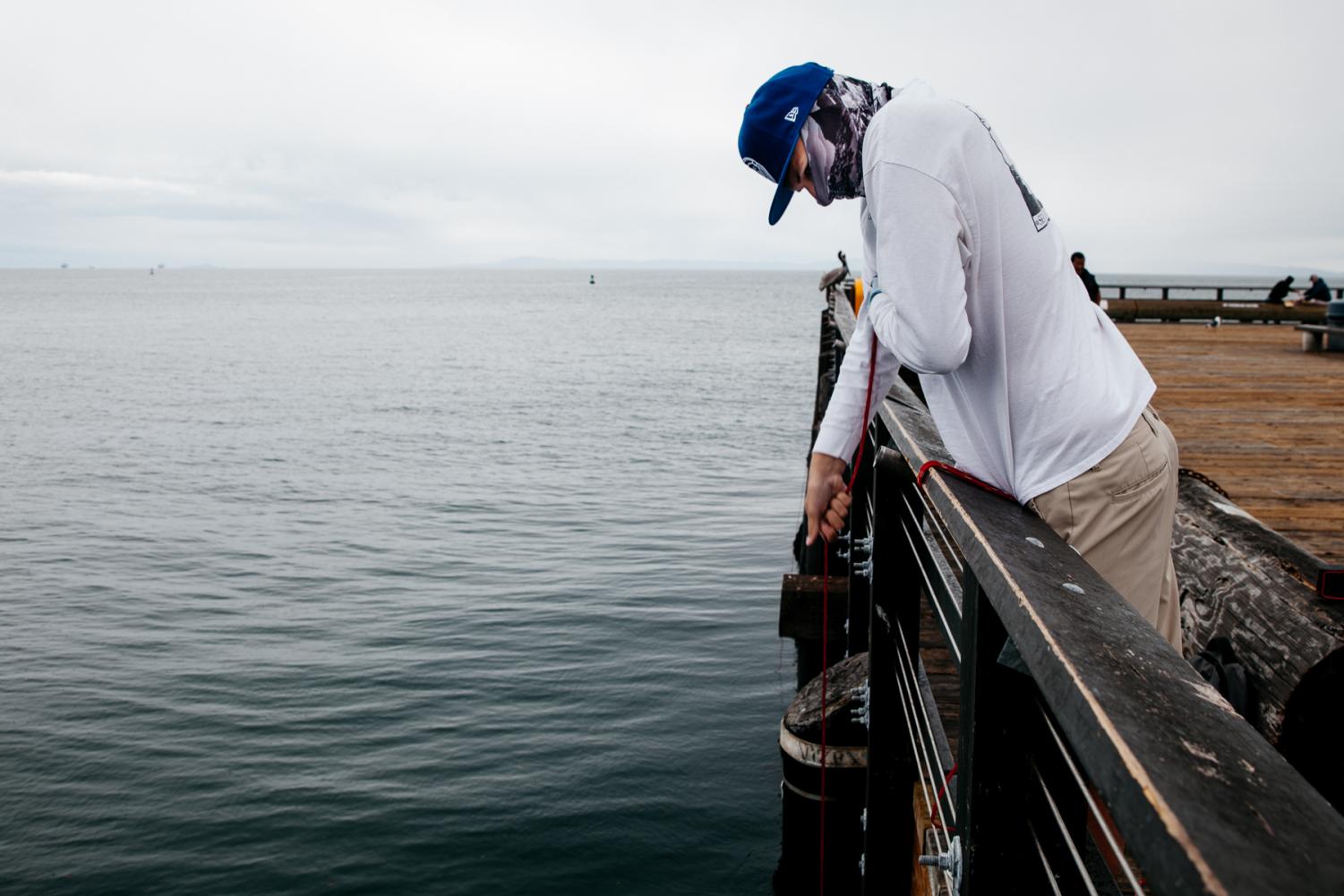 Taylor Carney has picked up crab fishing as a new hobby after losing his job at East Beach Batting Cages because of coronavirus and checks his trap for a catch on Tuesday, April 7, at Stearns Wharf in Santa Barbara, Calif. “You don’t need a license to trap crab off a dock in California, so I’m out here,” said Carney “better than sitting at home all day.” 