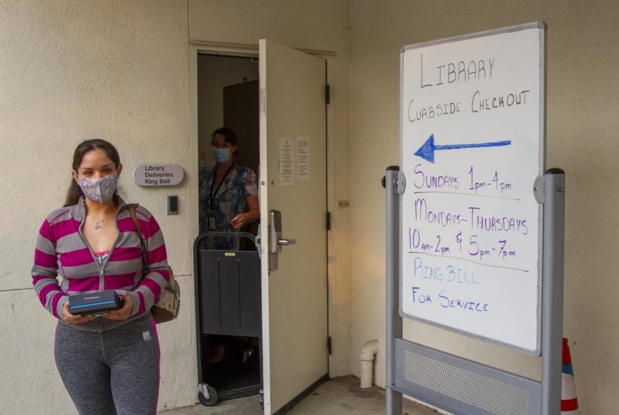 Anna Botello checks out a Wi-Fi hotspot from City College Librarian Ellen Carey on Tuesday, Sept. 8, 2020 at Luria Library in Santa Barbara, Calif. The Library is open most days for technology checkouts.