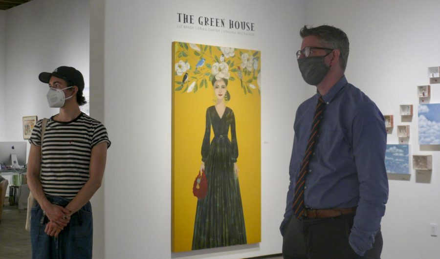 Jeremy Tesmer, right, and Sam Johnson looking at art on the walls of the Sullivan Goss Gallery on Oct. 4 in Santa Barbara, Calif. The gallery has remained open with restrictions during the pandemic and exhibits show artists from all across the country. The painting in the background “The Green House” was made by local artist Erika Carter.