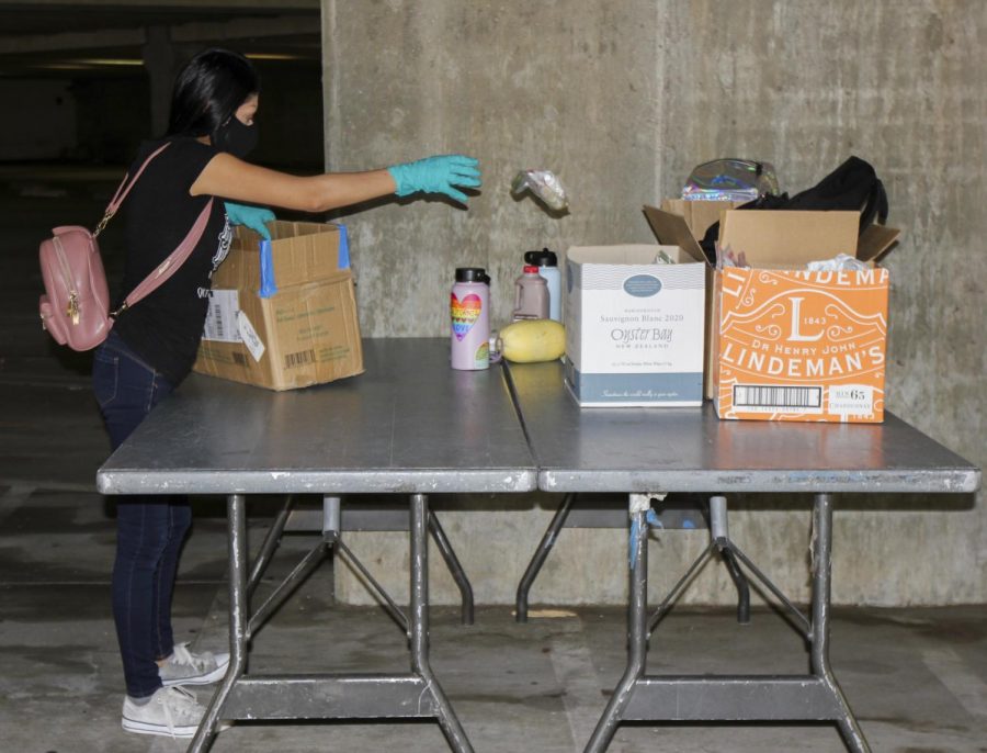 Alondra Lazaro Gonzalez clean’s up after the food distribution event on Oct. 14, 2020, in the West Campus parking lot at City College, in Santa Barbara, Calif. Everyone in the community is welcomed to the distribution, Lazaro Gonzalez said. We never say no to people who are hungry.