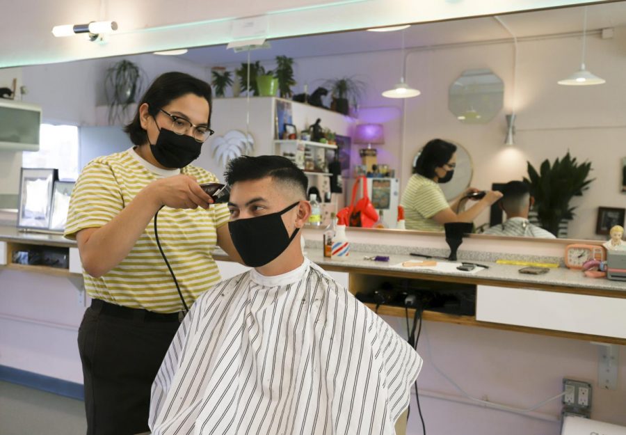 Erin Guereña trims up long-time returning client Tyler Silvestre's hair on Nov. 19, 2020 at Haven Barber Shop at 1924 De La Vina St. in Santa Barbara, Calif. “I don't even need to look at it,” Silvestre said to Guereña. “Your hair cuts are perfect every time.”