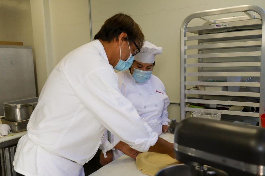 Chef Stephane Rapp helps Aurora Hernandez place her pie crust in the pan on Nov 24, in the Kitchen of the Cafeteria at City College in Santa Barbara, Calif. Class sizes are smaller because of the new class structures resulting in two LTA’s and one teacher per student in the department.