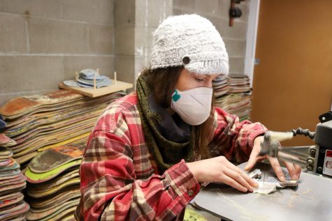 Inga Guzyte cuts off a small portion of a reflection piece from a skateboard to add detail to a new portrait she started recently on Nov. 30 at her studio in Santa Barbara, Calif. Every detail in each of her pieces is inlaid and not just layered on top of each other.