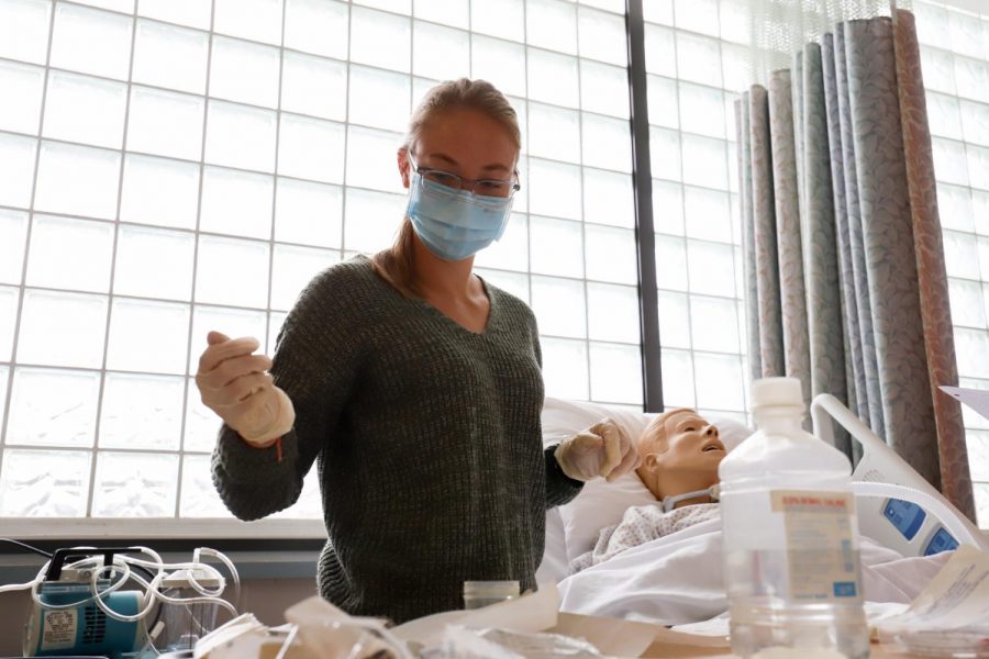 Brea Cook examines her tray of medical supplies set up to ensure everything is in order before changing the dressing of the mannequin tracheostomy patient on Feb. 9 2021 at the Nursing Lab in the City College Administration building in Santa Barbara, Calif. Nursing students work in groups of 2-3 during labs where they work on fake patients that simulate real experiences.