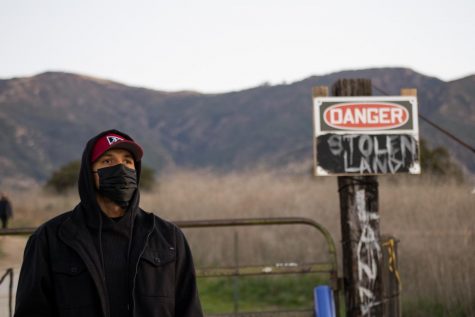 Protester Roy Schulte watches the scene at the sit-in protest on Feb. 26, 2021, at the San Marcos Foothills Preserve in Santa Barbara, Calif. Schulte stayed overnight in support of those trying to protect the land from development.