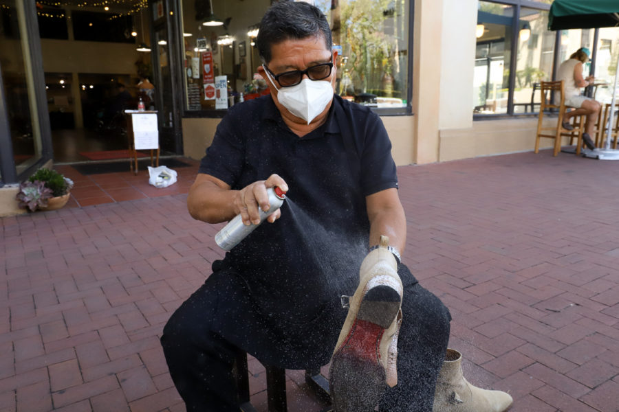 Lopez preps the suede boot with a protecting spray before taking a 120-grit square of sandpaper to soften the material and remove the grease stain from the boot. Lopez, who worked inside Nordstrom for 26 years shining shoes, said he prefers being outside because of all the people that walk past. “I like the people,” he said. “I like the talking.”