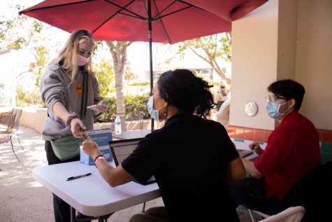 From left, student Erika Bolt shows her ID as City College employees Corlei Prieto and Javier Estevez enter her COVID-19 vaccine information into City College’s database on Sept. 16 at City College in Santa Barbara, Calif. The school incentivized students to get COVID-19 vaccines by offering $100 cash for students who uploaded their proof of inoculation.