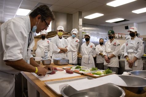 Chef Stephane Rapp demonstrates the proper technique for cutting sashimi on Oct. 13 during a culinary class at City College in Santa Barbara, Calif. To make cutting the flesh into bite-sized pieces easier, Rapp first showed how to cut off tough muscle and tendons.