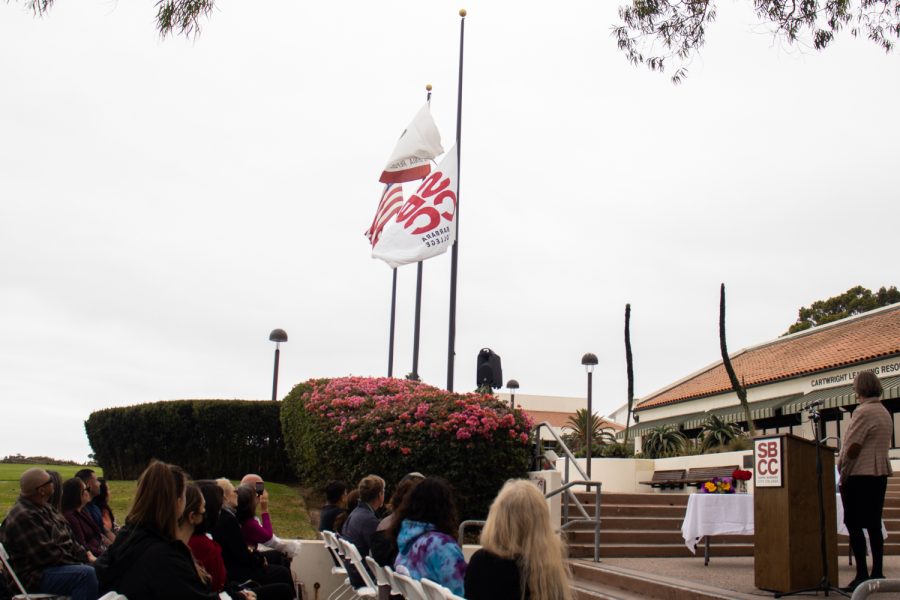 Interim Superintendent-President Kindred Murrillo joins the audience in observing the lowering of City College’s flag to honor recently deceased student Greigary Fingerle on Sept. 27 at City College in Santa Barbara, Calif. The flag is put at half-mast to metaphorically make room for the invisible flag of death.