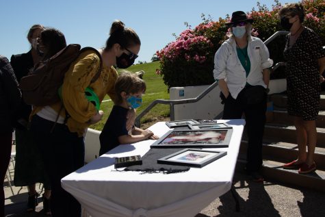 Academic Senate President and Chemistry Department Chair Raeanne Napoleon and her 6-year-old son Elroy look over pictures honoring deceased DSPS faculty member Janet Hose during a flag lowering ceremony honoring Hose’s life and services to City College on Monday, Oct. 18 outside of The Luria Library in Santa Barbara, Calif. About 30 of Hose’s friends and colleagues congregated in remembrance of her.