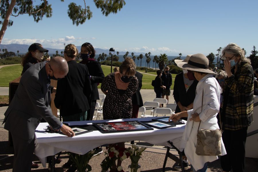 Retired DSPS Learning Disability Specialist Lesley Taylor, center, surrounded by friends and colleagues of deceased DSPS faculty member Janet Hose, examines a table laden with pictures of Hose during a flag lowering ceremony to honor her life and services to City College on Monday, Oct. 18 outside of The Luria Library in Santa Barbara, Calif. Hose's family, who live on the east coast, told City IT User Support Services Director and College Chaplain Jason Walker they were sad they could not attend.