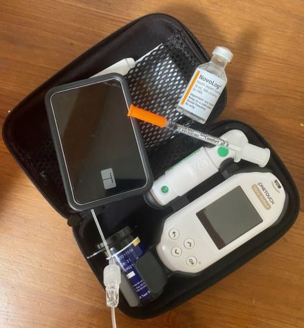 Different tools used to treat diabetes. The set includes insulin, which is the medicine needed to take in order to keep blood sugar levels under control, an insulin pump worn to administer the insulin, needles carried around in case the pump runs out of battery and a testing kit to check blood sugar levels.