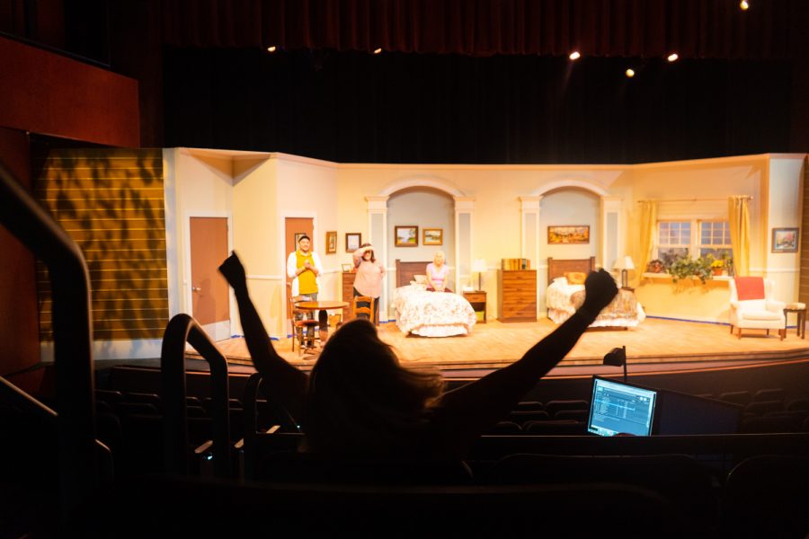 Katie Laris, theatre arts department co-chair and director of “Ripcord”, demonstrates how she’d like one of the actors to raise his arms for the ending of a scene on Oct. 6 in the Garvin Theatre at City College in Santa Barbara, Calif. The crew had to work on cutting the lights when the actor's arms went up.