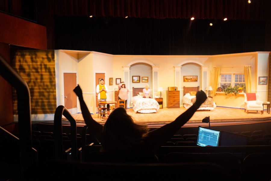 Katie Laris, theatre arts department co-chair and director of “Ripcord”, demonstrates how she’d like one of the actors to raise his arms for the ending of a scene on Oct. 6 in the Garvin Theatre at City College in Santa Barbara, Calif. The crew had to work on cutting the lights when the actors arms went up.