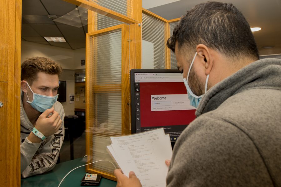 A City College student comes to the Admissions counter and shows his transcripts to new student applications and registrations specialist Eduardo Contrares on Nov. 2 in City Colleges Student Services building in Santa Barbara, Calif. Because of COVID-19 safety, the center is closed Mondays and Fridays.