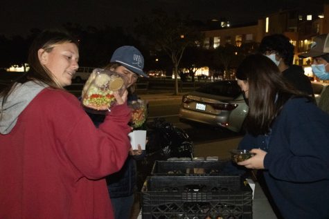 From left, UCSB students Hazel Johnson and Sarah Olsen admire the selection available at the distribution from Food Not Bombs Isla Vista on Wednesday, Nov. 17 in Isla Vista, Calif. Mediterranean and Thai-style salads were given that night, as well as vegetable stew and rice.
