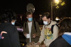 From left, Diego Zahnen and Julian Broadbery select meals from the Food Not Bombs Isla Vista distribution on Wednesday, Nov. 17. Zahnen and Broabdery are among the roughly 300 students housed in hotels during UCSB's fall quarters.