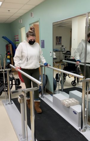 Sydney Hammer takes her first steps with the help of handrails after recovering from surgery on Jan. 31, 2021 at Kaiser Permanente in Wheat Ridge, Colorado. Hammer broke her wrist, arm and femur from falling 13 feet off her balcony. Image courtesy of Sydney's mother, Sandra Hammer.