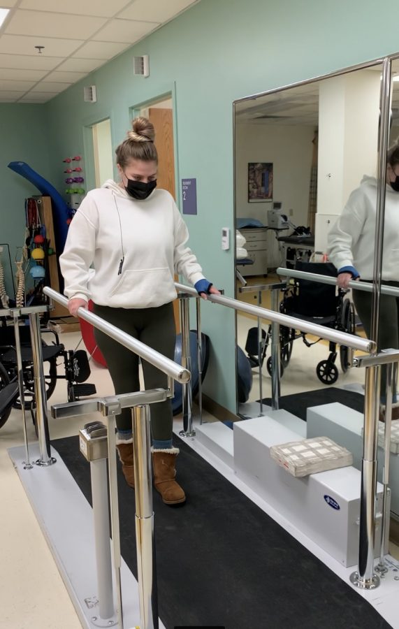 Sydney Hammer takes her first steps with the help of handrails after recovering from Surgery on Jan. 31, 2021 at Kaiser Permanente in Wheat Ridge, Colorado. Hammer broke her wrist, arm and femur from falling 13 feel off her balcony. Courtesy of Hammers mom, Sandra Hammer.