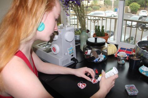 Claire Kimball applies glue on the tags for a set of choker necklaces on Thursday, Dec. 2 at Santa Barbara, Calif. Kimball sells her jewelry on her website and promotes the pieces on Instagram.