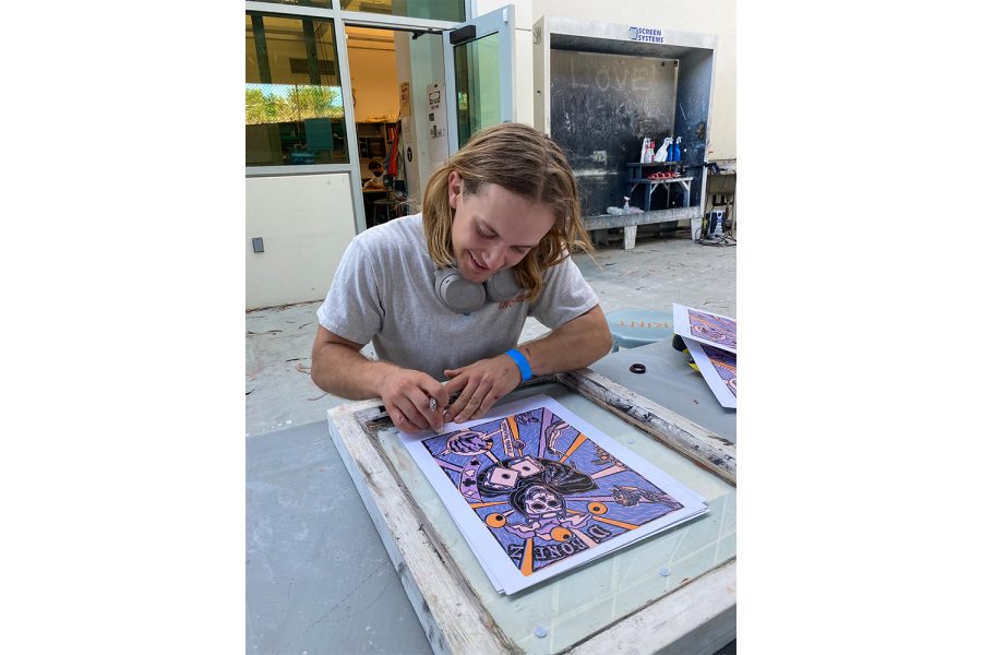 Maurice Green finishes his most recent print design in the humanities building at Santa Barbara City College on March 18. Green hand prints custom art designs onto second hand clothing found in thrift stores or by donations from friends.