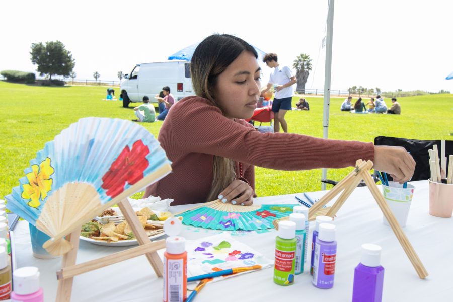Carmina Cabatic decorates a Mexican fan during the "Unity In The CommUNITY" festival on April 27 in Santa Barbara, Calif. Several different cultural backgrounds were represented with different booths during the festivities, with some offering native dishes and traditional crafts. 