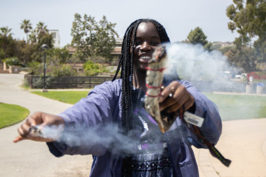 Business major Aida Pouye burns sage over herself during the "Unity In The CommUNITY" festival on April 27 in Santa Barbara, Calif. Different activities were offered to festival-goers, including fan painting, ball toss and open poetry reading. 