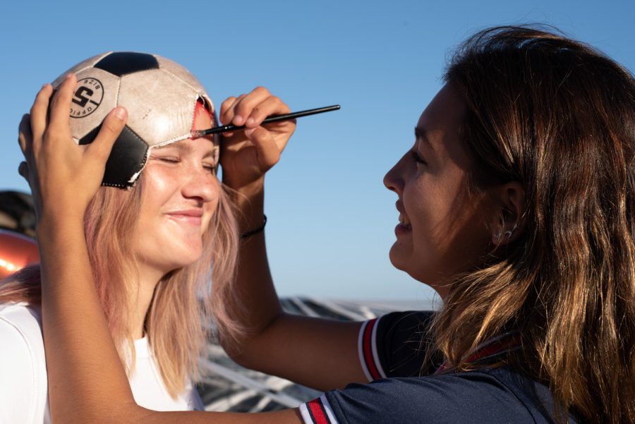 Athena Bow-Graham brushes red paint around the edges of Kiersta Gurney’s soccer ball hat on Oct. 27 at City College’s Great Meadow in Santa Barbara, Calif. Bow-Graham and Gurney are teammates on the City College Women’s Soccer team and worked together to hand out candy to Trunk-or-Treaters.