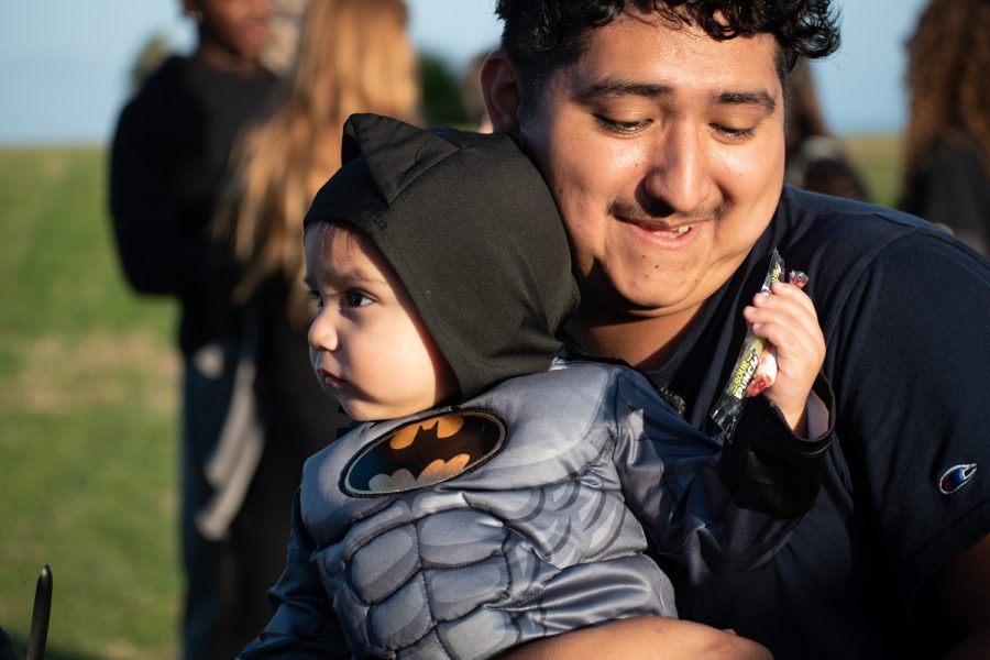 Demetrio Martinez holds his son, Demetrio Martinez, after collecting candy from a trunk station on Oct. 27 at City College’s Great Meadow in Santa Barbara, Calif. Children of all ages were later able to participate in a costume contest for a chance to win prizes.