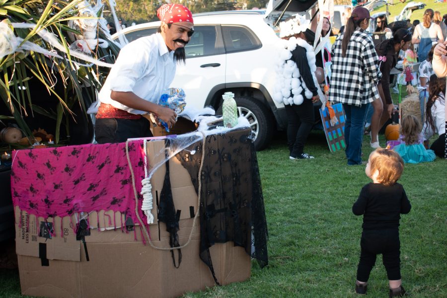 Mark Hernandez smiles down toward Aubrey Revilla after handing her candy on Oct. 27 at City College’s Great Meadow in Santa Barbara, Calif. Hernandez’s pirate-themed trunk featured a full ship crew and was a hit among guests.