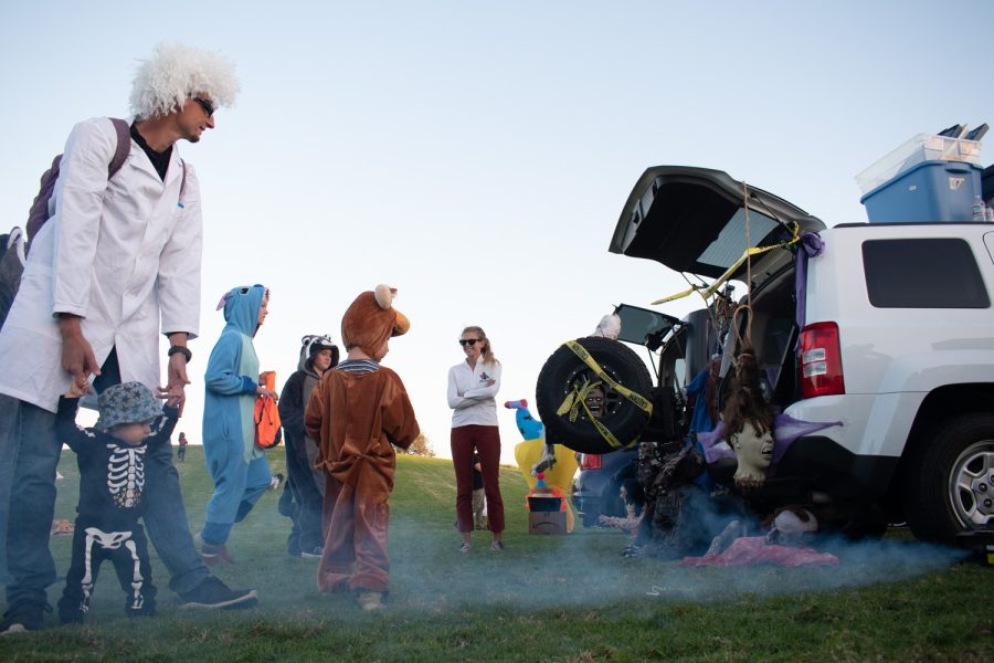 Mathias Payer (far left) holds up the arms of his daughter, Kiara Payer, as they curiously observe the vapor emanating from a nearby fog machine on Oct. 27 at City College’s Great Meadow in Santa Barbara, Calif. Each trunk display at the event revolved around a unique theme with a variety of decorations and effects.