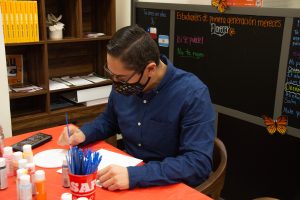 Professor Hector Eduardo Gamero painting a half butterfly half heart along with words of encouragement for dreamers on Oct. 19 at the Center for Equity & Social Justice in Santa Barbara, Calif. The paintings will be put up on the wall for everyone to see as inspiration.