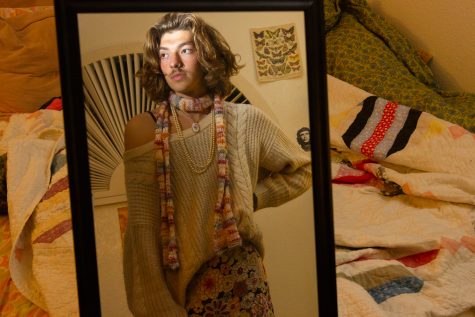 Spencer Rosin dressed in a thrifted knit sweater and colorful, floral skirt paired with a scarf and pearls on Nov. 14 in front of a mirror inside his bedroom in Isla, Vista, Calif. Rosin uses fashion as a way to express himself, and loves to “play” with gender through his clothing.
