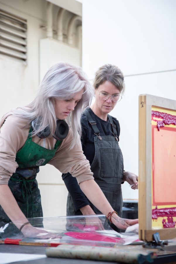 Gigi Macioce (left) receives guidance from Professor of Printmaking Stephanie Dotson as she works on the printing press on Nov. 17 at City College in Santa Barbara, Calif. The collaborative workspace encouraged by Dotson empowers students to pass along skills to others