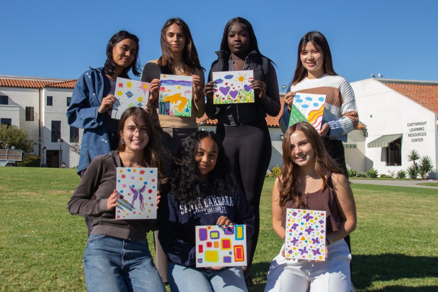 The Women For Success Club photographed with their finished canvases on Nov. 3 on the Great Meadow at City College in Santa Barbara, Calif. The top row (from left) includes Divya Ramesh, Raphaela Griffith, Naya Ruot and Momoko Nakao. The bottom row (from left) consists of Lexa Welch, Andrianina Rajaosera and Elizabeth Wilmer.