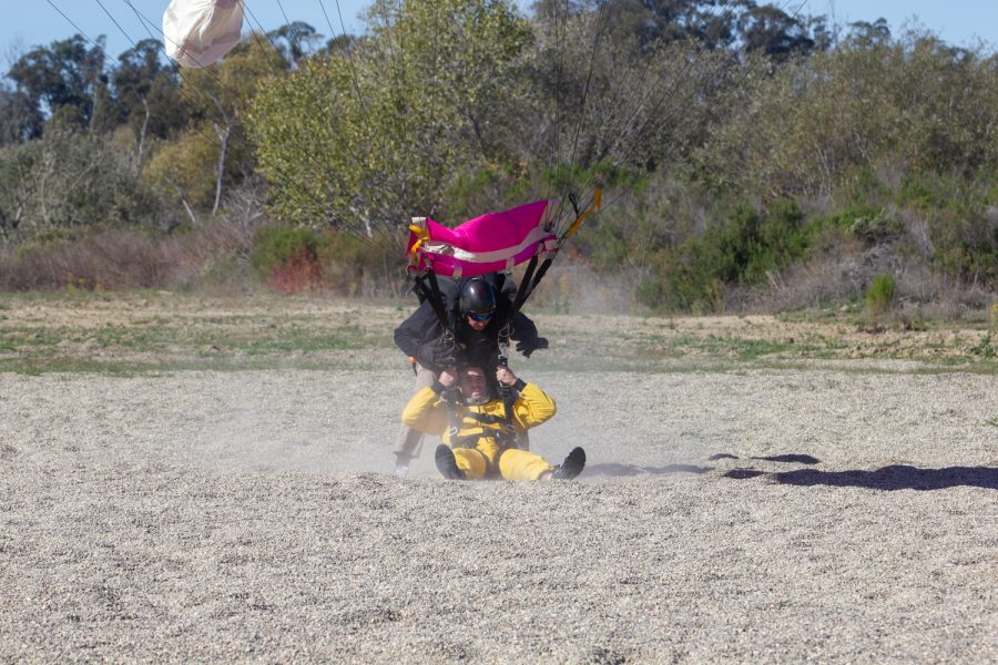 Tom Pecharich unlatches his jumpers harness from his right as they touch the ground on Nov. 20 at Skydive Santa Barbara in Lompoc, Calif. Jumpers land in a seated position while their instructors land standing up in order to make sure the parachute does not continue to get pulled if there is wind.