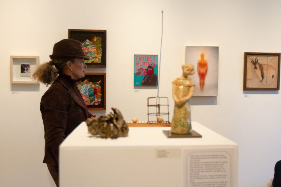 A visitor walks alongside the wall, lined with artful displays on Feb. 15 at the Small Images Exhibition in the Atkinson Gallery in Santa Barbara, Calif. The pieces of art were displayed in a circular arrangement around the room, and several displays stood on podiums throughout the open space inside.