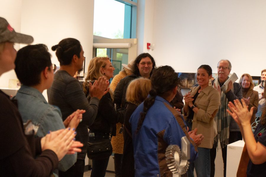 Spectators join together in a syncronized applause for award winner Kevin (center) on Feb. 15 at the Small Images Gallery in the Atkinson Gallery. Kevin was awarded the award for his