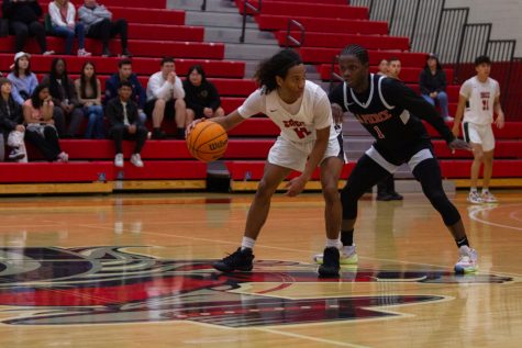 Number 11, Wilfred Nado, dribbles the ball around an opponent on Feb. 5, 2023, at City College in Santa Barbara, Calif. The game ended in a hard-won victory for City College's basketball team.